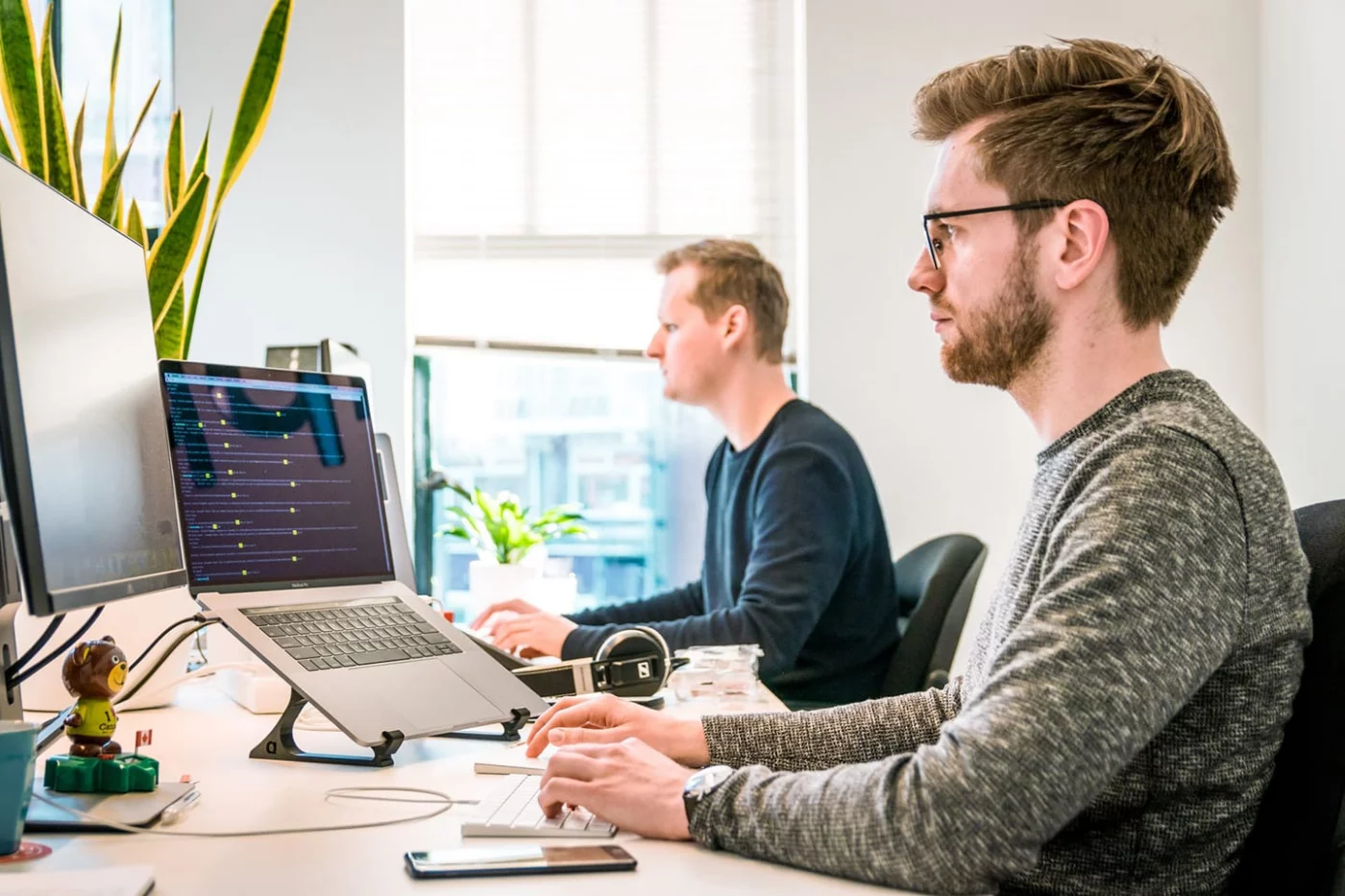 Zwei IT-Techniker arbeiten an Bildschirmen im Büro