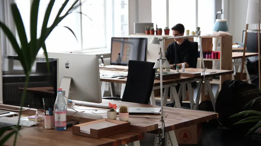 Mitarbeiter an mehreren Monitoren im Büro